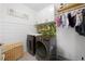 Modern laundry room with white cabinets, gold fixtures, front load machines, and decor at 30045 Southwell Ln, Wesley Chapel, FL 33543