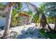 Backyard featuring lush tropical landscaping, gravel, and a well-kept exterior wall at 305 160Th Ter, Redington Beach, FL 33708