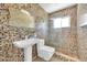 Modern bathroom with multi-colored tile walls, sleek pedestal sink and glass-enclosed shower showcasing contemporary design at 305 160Th Ter, Redington Beach, FL 33708