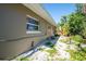 Exterior view of a well-maintained home with gravel landscaping and a window at 305 160Th Ter, Redington Beach, FL 33708
