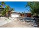 Charming single-story home featuring an attached garage, front deck, and tropical landscaping at 305 160Th Ter, Redington Beach, FL 33708
