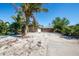 Charming home exterior featuring tropical landscaping and concrete driveway at 305 160Th Ter, Redington Beach, FL 33708