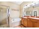 Bright bathroom features a glass enclosed shower and soaking tub with double sink vanity at 31836 Stillmeadow Dr, Wesley Chapel, FL 33543