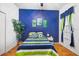 Bright bedroom with a blue accent wall, hardwood floors, and modern decor at 31836 Stillmeadow Dr, Wesley Chapel, FL 33543