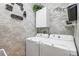 Convenient laundry room featuring modern washer and dryer, decor, and brick accents at 31836 Stillmeadow Dr, Wesley Chapel, FL 33543