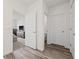 Hallway with wood flooring, a view into the bedroom, and a full bathroom on the right at 31923 Treasure Dock Isle, Wesley Chapel, FL 33545