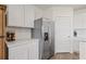 Modern kitchen with stainless steel fridge, white cabinets, and ample counter space at 31923 Treasure Dock Isle, Wesley Chapel, FL 33545