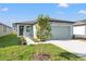 Single-Gathering home with a two-car garage, tidy landscaping, and a newly planted tree at 3637 Moscato Dr, Brooksville, FL 34602