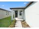 Inviting covered front porch with a dark-colored front door and manicured garden at 3637 Moscato Dr, Brooksville, FL 34602