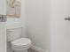 Bright powder room featuring a toilet, white walls, and gray vinyl floors at 3637 Moscato Dr, Brooksville, FL 34602