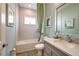 Bathroom featuring a tub with shower, single sink vanity with mirror, and tiled walls at 3915 Farm Garden Ct, Lakewood Ranch, FL 34211