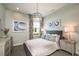 Light-filled bedroom with a queen-size bed, floral curtains, pendant lighting, and gray walls at 3915 Farm Garden Ct, Lakewood Ranch, FL 34211