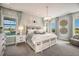 A bright bedroom with light blue walls, carpet floors, a pendant light, and two bedside tables at 3915 Farm Garden Ct, Lakewood Ranch, FL 34211