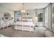 A bright bedroom with light blue walls, carpet floors, a pendant light, and two bedside tables at 3915 Farm Garden Ct, Lakewood Ranch, FL 34211