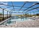 The in-ground pool features brick pavers, an integrated spa, and a sun shelf, all surrounded by a screened enclosure at 3915 Farm Garden Ct, Lakewood Ranch, FL 34211