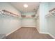 A large, well-organized walk-in closet with built-in shelving, carpeted flooring, and a center aisle at 3915 Farm Garden Ct, Lakewood Ranch, FL 34211