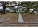 Inviting home with a vibrant green door, complemented by mature trees and a neatly maintained yard at 4162 3Rd N Ave, St Petersburg, FL 33713
