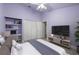 This is a cute bedroom featuring built in shelving, a TV and a ceiling fan for added comfort at 4324 Auston Way, Palm Harbor, FL 34685