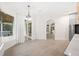 Bright dining area with white chairs, wood table, and view to hot tub and front door at 4324 Auston Way, Palm Harbor, FL 34685