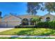 Attractive home with a two-car garage, lush green lawn, manicured bushes and a stone-accented facade at 4324 Auston Way, Palm Harbor, FL 34685