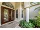Inviting front entryway with a wood door, brick walkway, and decorative landscaping, creating a warm welcome at 4324 Auston Way, Palm Harbor, FL 34685