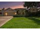 Charming home at dusk featuring a well-manicured lawn, neutral exterior, and an attached two-car garage at 4324 Auston Way, Palm Harbor, FL 34685
