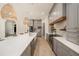 Modern kitchen with a large quartz island, gray cabinets, wooden accents, and stainless steel appliances at 4324 Auston Way, Palm Harbor, FL 34685