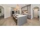 Open kitchen with a large island, seating, gray cabinetry, pendant lights, and stainless steel appliances at 4324 Auston Way, Palm Harbor, FL 34685