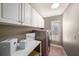 Well-organized laundry room with overhead cabinets, folding area, modern washer and dryer, and window at 4324 Auston Way, Palm Harbor, FL 34685