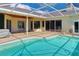 The outdoor pool area has a patio, screened-in enclosure, and sliding glass doors for easy access at 4324 Auston Way, Palm Harbor, FL 34685