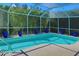 The screened-in pool area features a beautiful turquoise pool and lots of potted plants at 4324 Auston Way, Palm Harbor, FL 34685