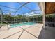Enclosed in a screened lanai, a sparkling pool is surrounded by lush green landscaping and vibrant blue planters at 4324 Auston Way, Palm Harbor, FL 34685