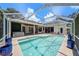 Aerial view of a beautiful pool and hot tub, framed by a screened-in enclosure with patio and manicured greenery at 4324 Auston Way, Palm Harbor, FL 34685