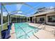 Sparkling pool enclosed by a screened lanai, complemented by lush greenery and a covered patio with a hot tub at 4324 Auston Way, Palm Harbor, FL 34685