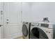 Bright laundry room featuring stainless steel, front load washer and dryer units near a white door at 4907 Bayshore Blvd # 115, Tampa, FL 33611
