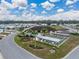 Community clubhouse with a pool, shuffleboard courts, flags, and landscaping surrounded by many homes at 4920 Blanco Dr, Zephyrhills, FL 33541