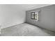 Empty bedroom featuring plush carpet, a window, and muted grey paint at 4920 Blanco Dr, Zephyrhills, FL 33541