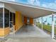 Covered parking area of a single-story home that provides sheltered access to the front door at 4920 Blanco Dr, Zephyrhills, FL 33541