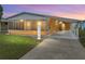 Charming single-story home featuring a screened-in porch, carport, and well-maintained lawn at 4920 Blanco Dr, Zephyrhills, FL 33541