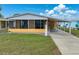 Charming single-story home featuring a screened-in porch, carport, and well-maintained lawn at 4920 Blanco Dr, Zephyrhills, FL 33541