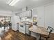 Functional kitchen featuring white appliances, a breakfast bar, and hardwood flooring at 4920 Blanco Dr, Zephyrhills, FL 33541