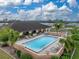 Aerial view of a rectangular community pool surrounded by lounge chairs and landscaping near the community clubhouse at 4920 Blanco Dr, Zephyrhills, FL 33541