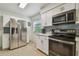 Well-lit kitchen with stainless steel appliances, white cabinets, and blue tile backsplash at 5121 15Th S Ave, Gulfport, FL 33707