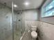 Modern bathroom featuring glass enclosed shower with marble-look tiling, and a window offering natural light at 5751 94Th N Ave, Pinellas Park, FL 33782
