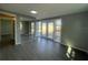 Bright bedroom has gray laminate flooring, a mirrored closet, and sliding glass doors leading to the backyard at 5751 94Th N Ave, Pinellas Park, FL 33782