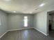 Light-filled living room has sleek gray flooring, recessed lighting, and neutral paint creating a clean and modern aesthetic at 5751 94Th N Ave, Pinellas Park, FL 33782