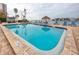 Sparkling community pool with plenty of lounge chairs, surrounded by tropical landscaping and waterfront views at 6025 Shore S Blvd # 410, Gulfport, FL 33707