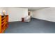 Spacious living room with blue carpeting and a cozy armchair, offering ample space for relaxation at 6025 Shore S Blvd # 410, Gulfport, FL 33707