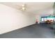 Expansive living area featuring blue carpeting, a ceiling fan, and dining area near a large window at 6025 Shore S Blvd # 410, Gulfport, FL 33707