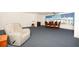 Bright living room with a large window and an armchair, featuring blue carpeting throughout the area at 6025 Shore S Blvd # 410, Gulfport, FL 33707
